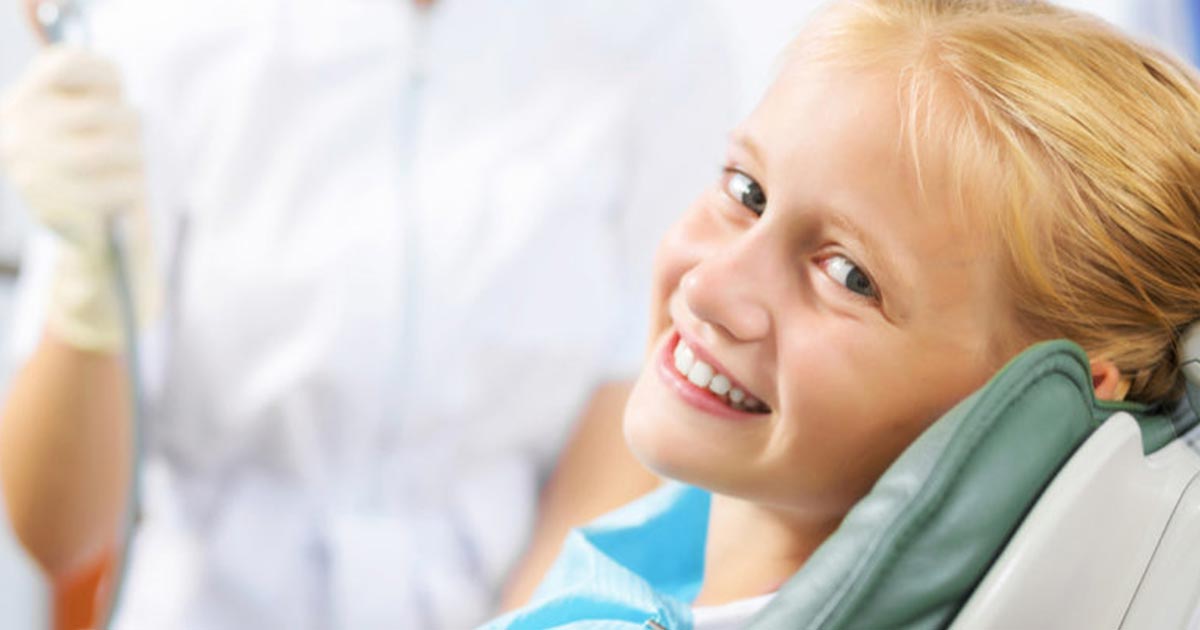 child in dentist chair smiling