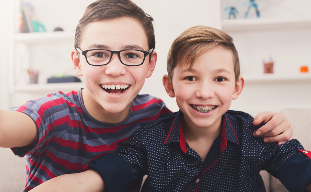 young children with braces smiling at camera