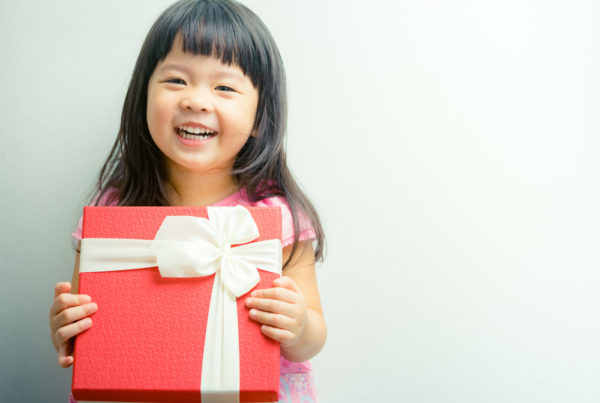 child-smiles-holding-gift