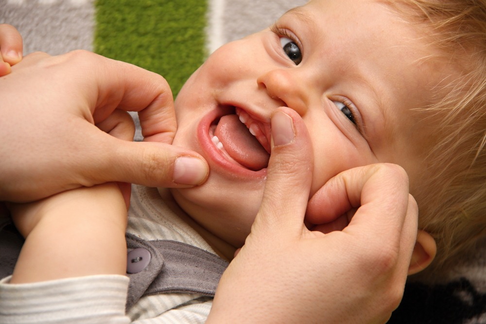 Parent checking child’s mouth after a baby tooth was knocked out from a fall or injury