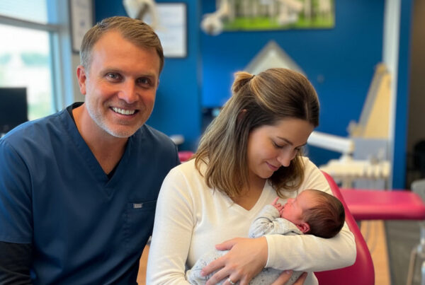 Parent holding an infant during a laser frenectomy consult at Kids Mile High